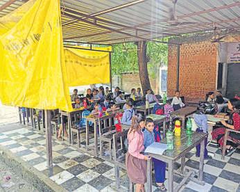Students attend classes under tarp; govt school awaits funds