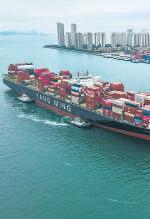 Cargo ships running on oil are cruising slowly into the sunset