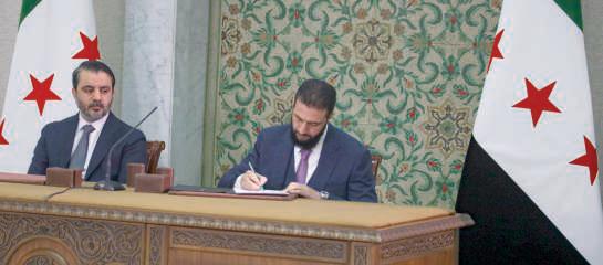 Syria leader signs temporary constitution