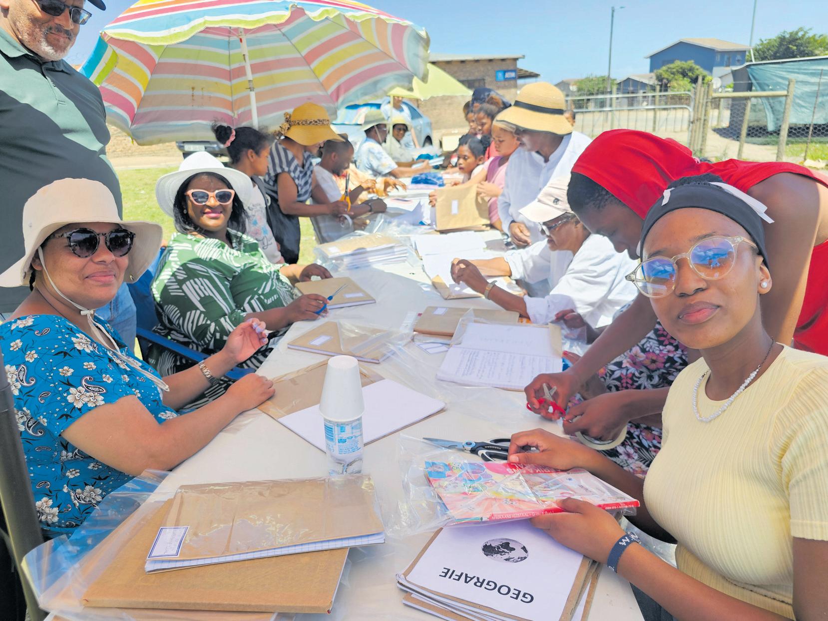 Mount Olives se vrywilligers help skoolboeke oortrek