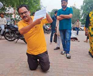 घुटनों पर चलकर जनसुनवाई में आवेदन देने पहुंचे व्यापारी सड़क निर्माण का कार्य अधूरा होने से हो रही परेशानी