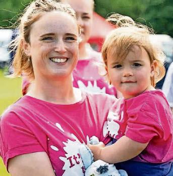 Nikki celebrates with tot Abbie as she fires gun for Race for Life