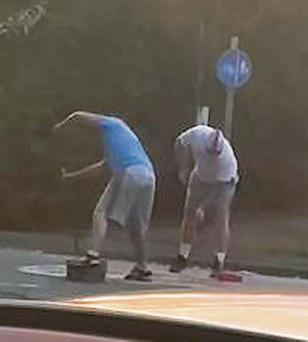 Men in masks filmed painting roundabout