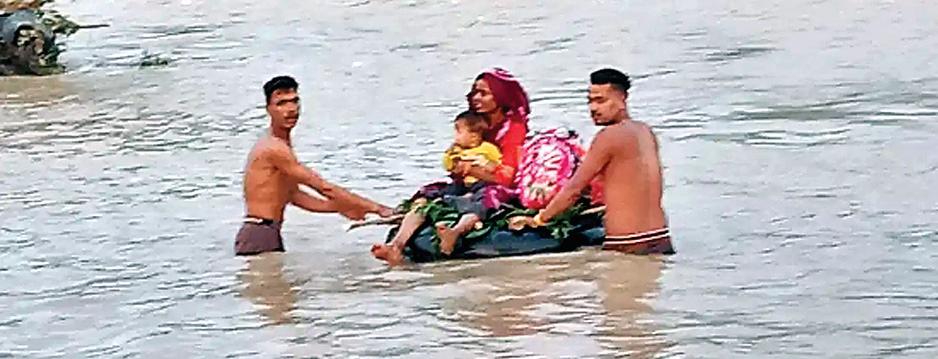 उफनती नदी, कंधों पर बच्चे, और सोया हुआ प्रशासन