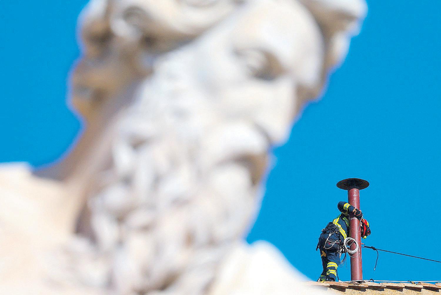 Workers install chimney atop Sistine Chapel for conclave