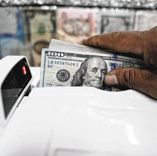 Greenback edges down after rising the most in three weeks