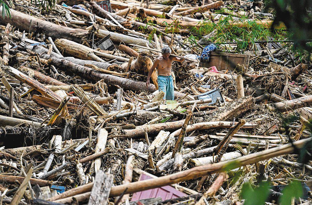 Floods in North Sumatra turn piles of timber into battering rams