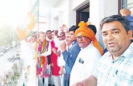 Dr Arvind Sharma unfurls BJP flag at his residence