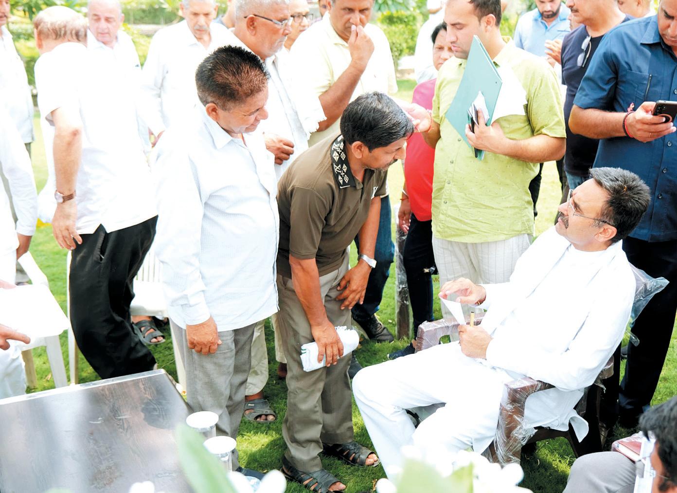 Speaker listens to problems of common people under a tree in afternoon