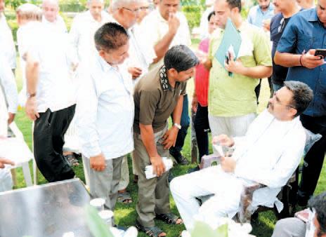 Speaker listens to problems of common people under a tree in afternoon