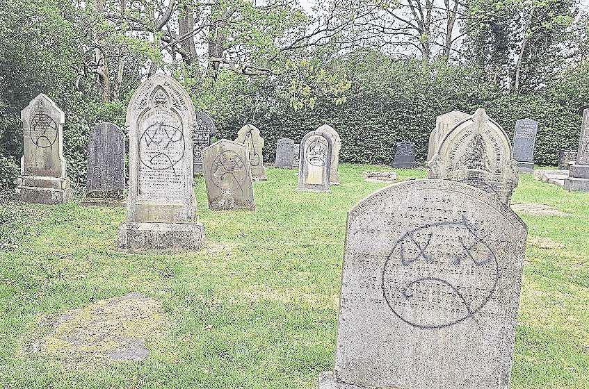 Vandals daub paint on church and dozens of gravestones