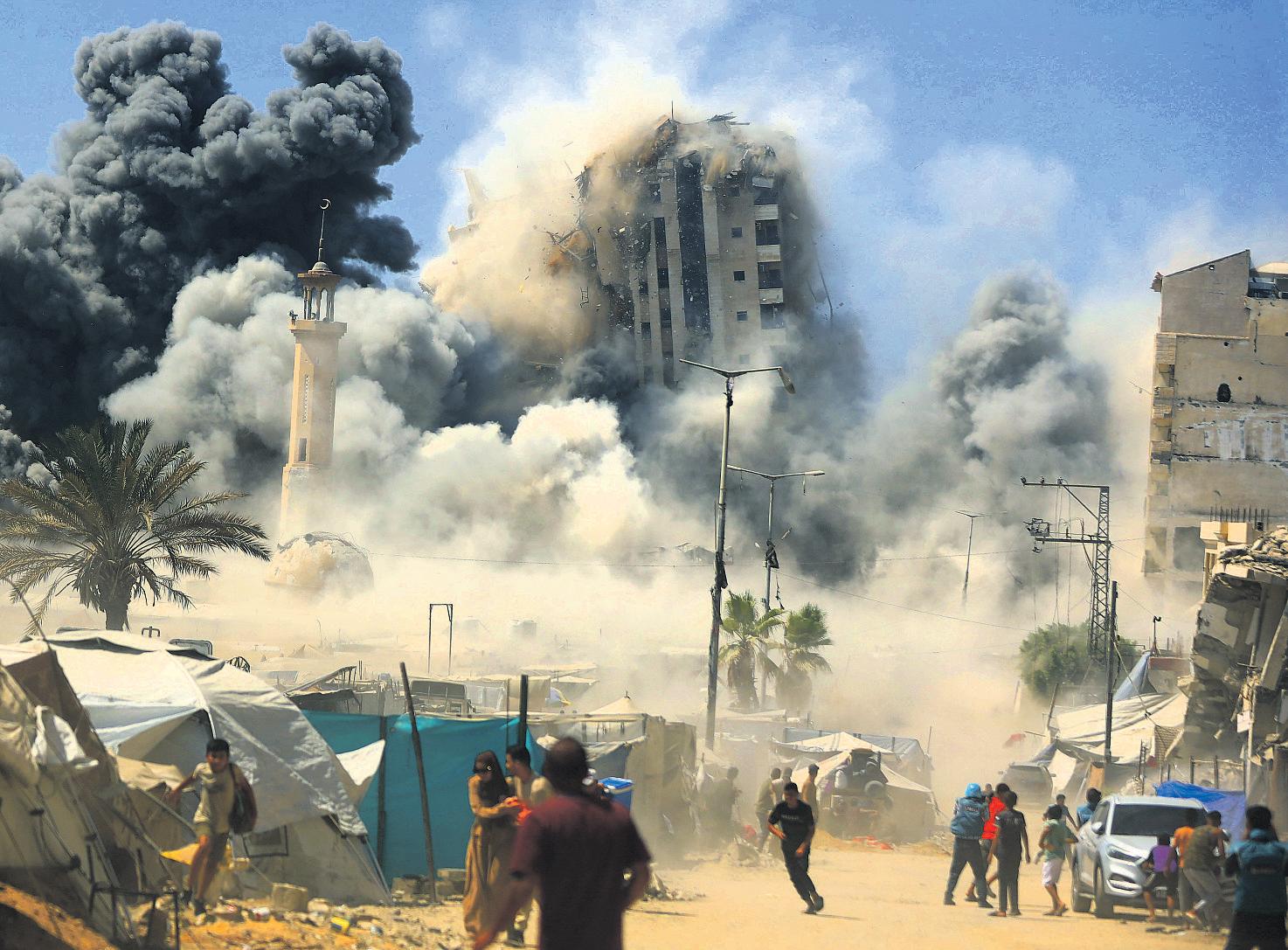 Israel strikes Gaza high-rise, threatens to hit more